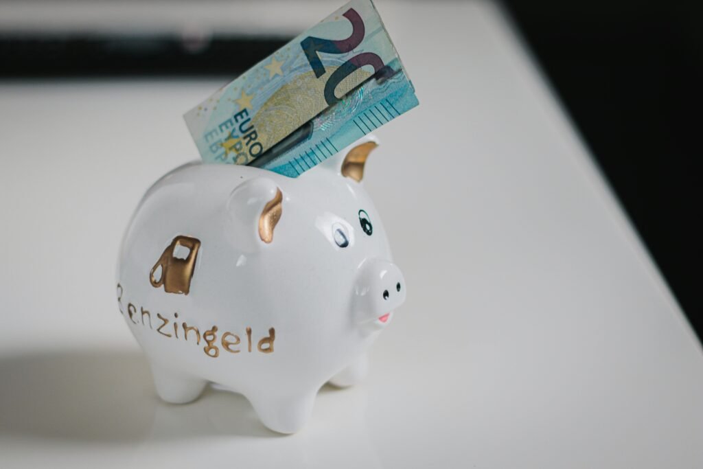 A white piggy bank with a €20 note inserted, symbolizing savings.